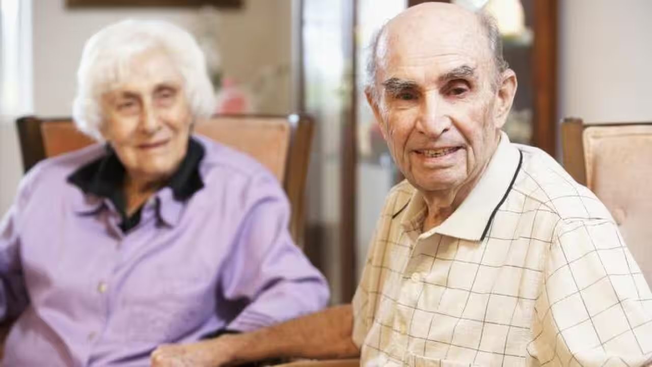 An older couple smiling together at home — celebrating connection and active ageing